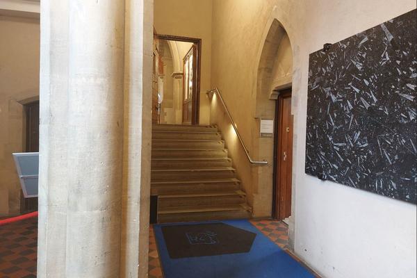 A view of the inside of the accessible entrance with a short corridor leading to some stairs. There is also a passage to the lift on the right.