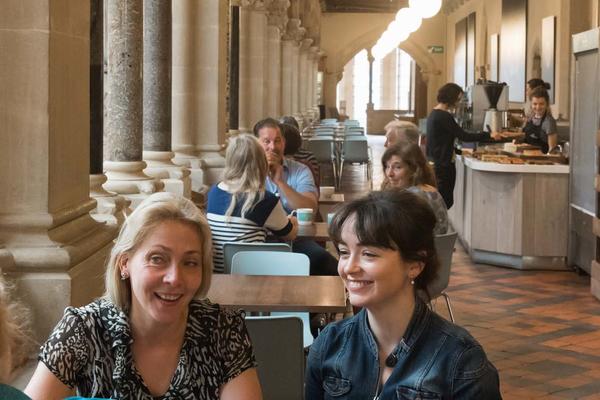 A view of the cafe where visitors are eating and drinking and someone is paying for food at the till